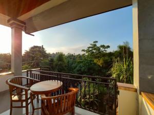 a balcony with a table and chairs and a view at Jero Ratna Homestay in Ubud