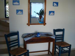 a dining room table with chairs and a painting on the wall at Philippos Studios & Apartments in Kardamaina