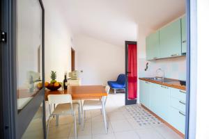 una cucina e una sala da pranzo con tavolo e sedie di Albergo Residenziale Stella Dell'Est a Bari Sardo