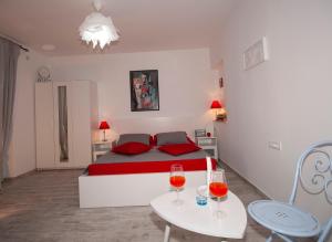 a bedroom with a bed and two tables with wine glasses at Apartments Barka in Tučepi