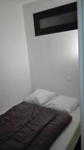 a bed with a black comforter on top of it at Charmant T2 avec cabine fermée et terrasse in Les Angles