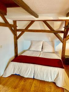Bett in einem Zimmer mit Holzbalken in der Unterkunft Ferienwohnungen Grimma 3 in Grimma