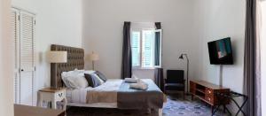 a bedroom with a bed and a tv and a chair at MYN in Rabat in Rabat