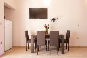 a dining room table with chairs and a television on the wall at Fortress View apartment in Kotor
