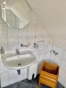 ein Badezimmer mit einem Waschbecken und einem Holzstuhl in der Unterkunft Ferienwohnungen Grimma 3 in Grimma
