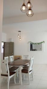 comedor con mesa y sillas blancas en Cameron Quintet Apartment @ Cameron Jaya en Cameron Highlands