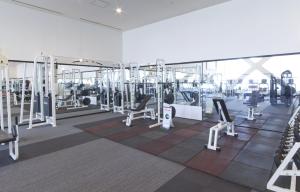 a gym with rows of tread machines and mirrors at Spa World HOTEL&RESORT in Osaka