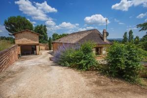a house on a dirt road next to a building at Gîte du Domaine de Coutancie in Prigonrieux