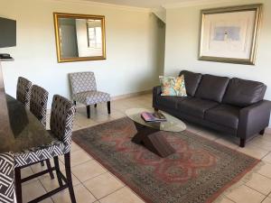 a living room with a couch and a table and chairs at Sandy Bottoms in Jeffreys Bay