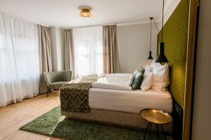 a hotel room with a bed and a chair at Weinhotel Freylich Zahn in Freyburg