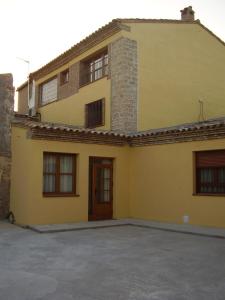 ein gelbes Haus mit einer Einfahrt davor in der Unterkunft Casa De Los Diezmos in Alborge
