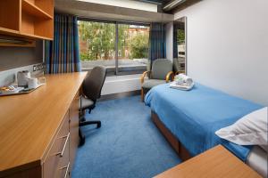 ein Hotelzimmer mit einem Bett, einem Schreibtisch und einem Fenster in der Unterkunft Christ's College Cambridge in Cambridge