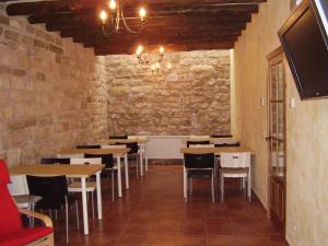 Alborge的住宿－Casa De Los Diezmos，一间设有桌椅的用餐室和砖墙