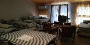 a living room with two beds a table and a television at Anandi Guesthouse Mariental in Mariental