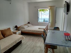 a room with two beds and a couch and a table at Apartments Jovanović in Perast