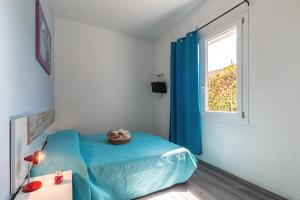 um quarto com uma cama azul e uma janela em B&B Più Mare em Santa Maria Navarrese