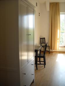un armario blanco en una habitación con una mesa y una silla en Agriturismo Campi Di Grano, en Roncade