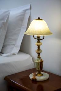 eine Lampe auf einem Tisch neben einem Bett in der Unterkunft Delightful 2 bedr'm 2 bathr'm apt with green roof top! - EP9U in Athen