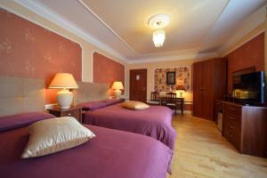 カジミエシュ・ドルニにあるCasablanca Pokoje i Apartamentyのベッド2台、薄型テレビが備わるホテルルームです。