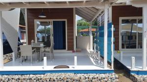 eine Veranda eines Hauses mit einem Tisch und Stühlen in der Unterkunft OURANOUPOLI BUNGALOWS & CAMPING in Ouranoupoli