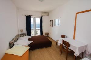 a bedroom with a bed and a table and a window at Apartments Elenora in Brist
