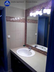 a bathroom with a sink and a mirror at Amelie Apartment in Preveza