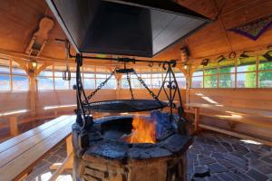 a fireplace in a wooden room with a tv above it at Dom Wczasowy Dunajec in Biały Dunajec