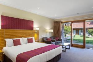 a hotel room with a large bed and a patio at Julie-Anna, Bendigo in Bendigo