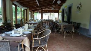 a row of tables and chairs in a restaurant at Valle Maira, Agriturismo nel Parco dei Nebrodi in Tortorici