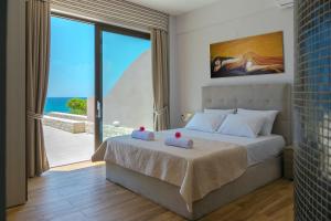 a bedroom with a bed with a view of the ocean at Mary Beach in Rodakino