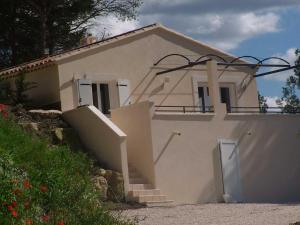 Une petite maison blanche avec des escaliers en face de celle-ci dans l'établissement B&B Villa Chante Coucou, à Fontaine-de-Vaucluse