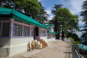 a building with a green awning and stairs outside at Glen View Heritage Homestay in Shimla