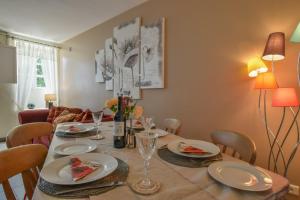 a dining room table with plates and glasses on it at La Maison Muguet in Civray