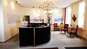 a kitchen with a black island in a room with chairs at Hotel zur Fürstabtei in Herford