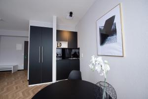 a living room with a table and a kitchen at V Business Appartments Stuttgart Magstadt in Magstadt