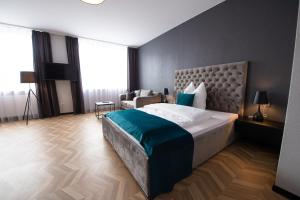 a bedroom with a large bed and a chair at V Business Appartments Stuttgart Magstadt in Magstadt