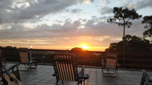 un groupe de chaises assises sur une terrasse pour admirer le coucher du soleil dans l'établissement Jeff Maker TW Workshop, à Emei