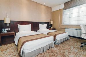 a hotel room with two beds and a window at Soluxe Hotel Almaty in Almaty