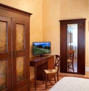 Rocca GrimaldaにあるTenuta Montebelloのベッドルーム(デスク、テレビ付)