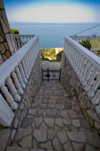 un escalier en pierre menant à un balcon donnant sur l'océan. dans l'établissement Apartments Dora, à Dobra Voda