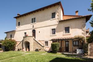 ein großes Steingebäude mit einem Hof davor in der Unterkunft Tenuta Decimo - Villa Dini in San Gimignano