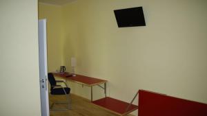 a room with a desk and a television on the wall at Workbase Hostel in Vienna