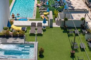 an overhead view of a pool with lawn chairs and a swimming pool at GHT Sa Riera in Tossa de Mar