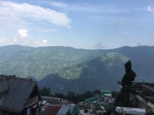 Blick auf eine Stadt mit Bergen im Hintergrund in der Unterkunft Benus in Darjeeling