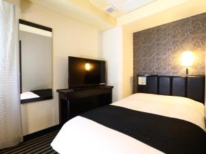 東京にあるアパホテル＜銀座京橋南＞（東京駅八重洲南）のベッドと薄型テレビがあるホテルの部屋