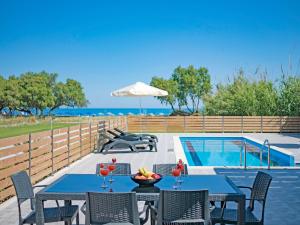 a patio with tables and chairs next to a swimming pool at Blue Oyster Villas in Platanes