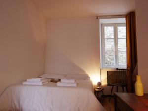 Un dormitorio con una cama con sábanas blancas y una ventana. en l'Otis et le Titouan Saint-Sauveur, en Dinan 5 fotos más