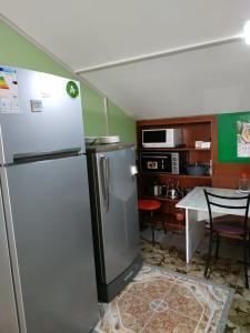 Il comprend une cuisine équipée d'un réfrigérateur et d'une table avec des chaises. dans l'établissement Hostel Portal, à Tbilissi