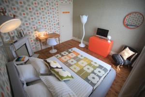 ein Schlafzimmer mit einem Bett, einem Sofa und einem Schreibtisch in der Unterkunft Chez Ric et Fer in Coucy-le-Château-Auffrique