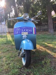 een blauwe scooter geparkeerd in het gras bij Residence Mariele in Tavazzano